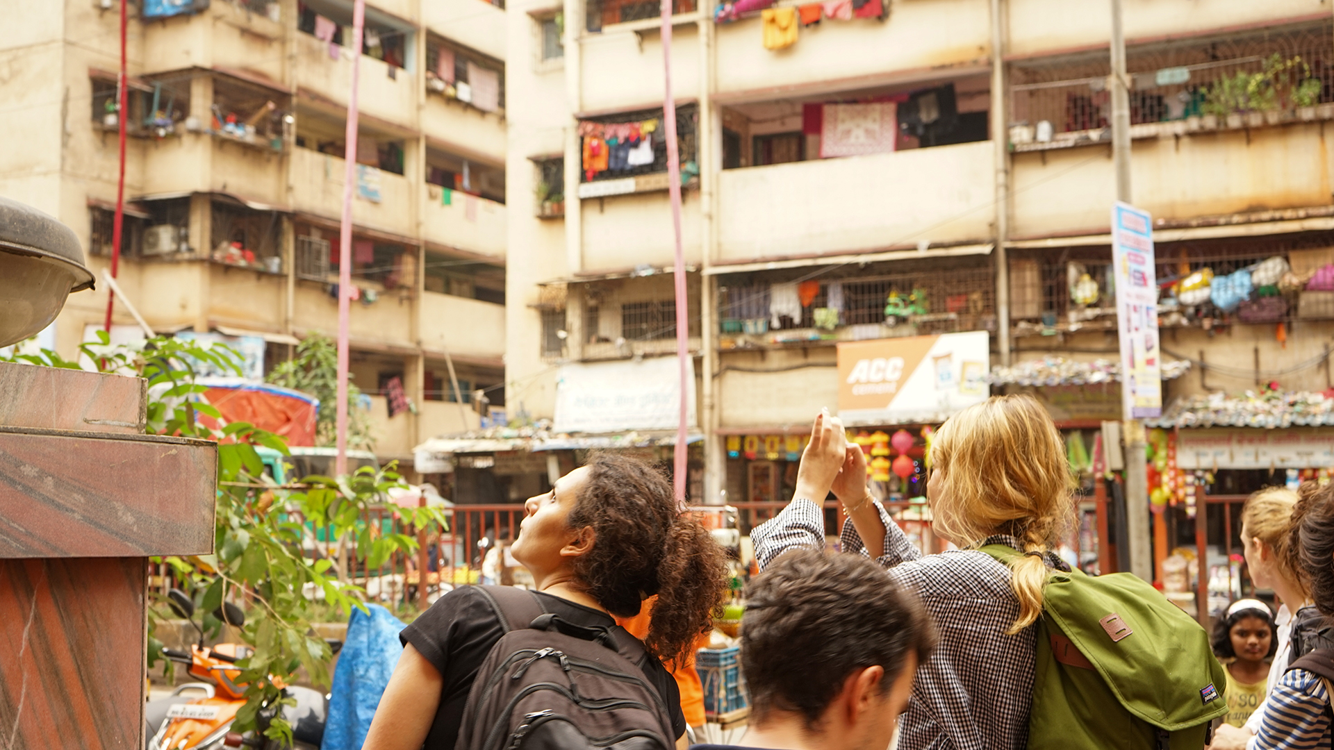 An Image of people with housing in the background in India